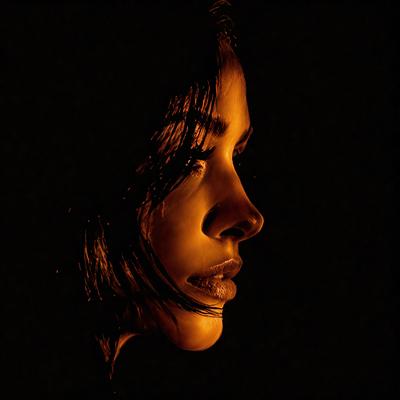 The primary subject of the image is a woman with long hair. She is looking directly at the camera, and her eyes are open. The setting is a dark room, and the visual style is a close-up of the woman's face. The colors in the image are predominantly dark, with the woman's hair being the most prominent feature. The overall atmosphere of the image is mysterious and captivating.